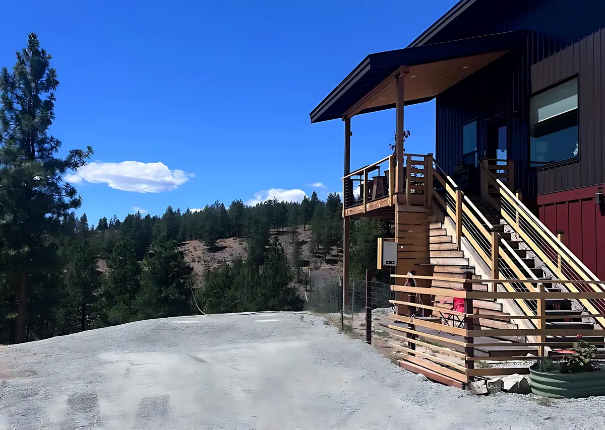 Finished crushed rock driveway and parking area in front of a house on a forested hillside