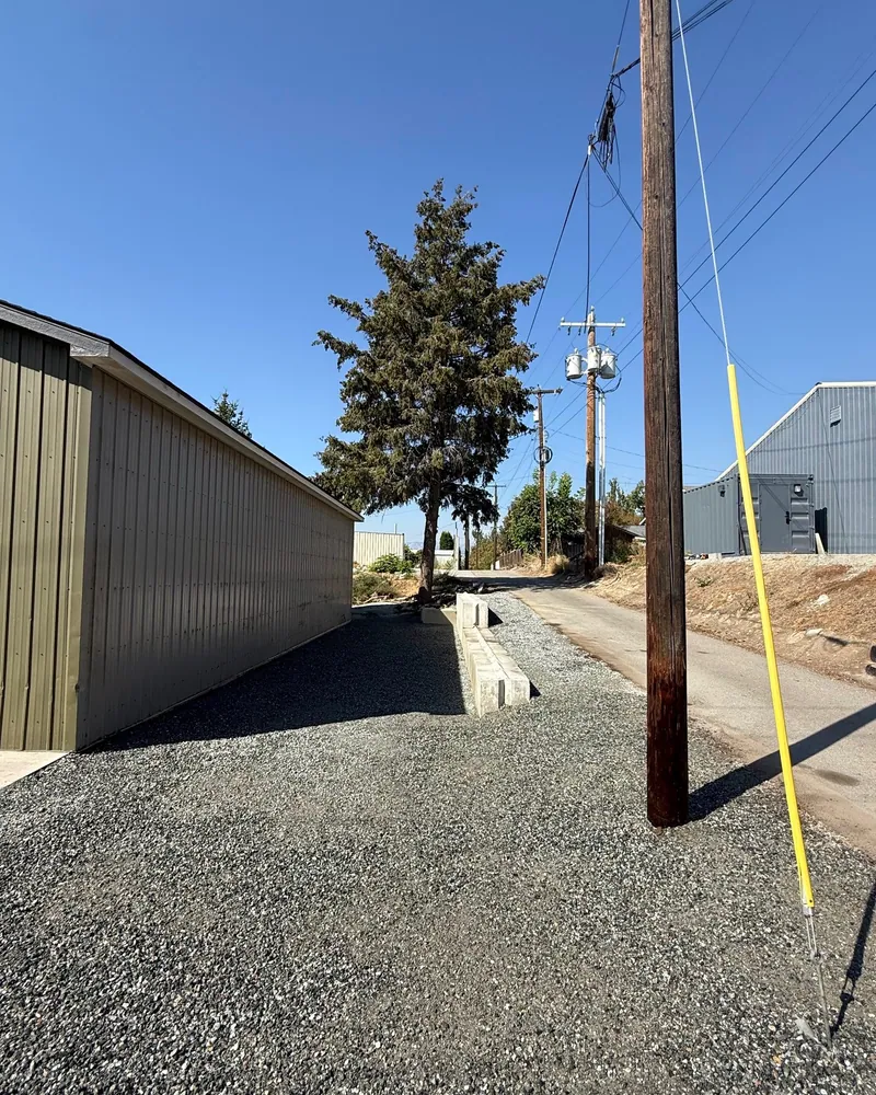 Wide view of the finished gravel strip and the block wall from the far end