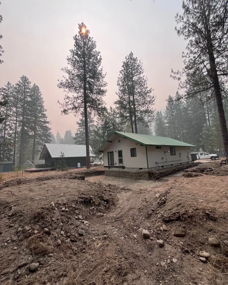 The house from the back with the ground cut and shaped away from the foundation